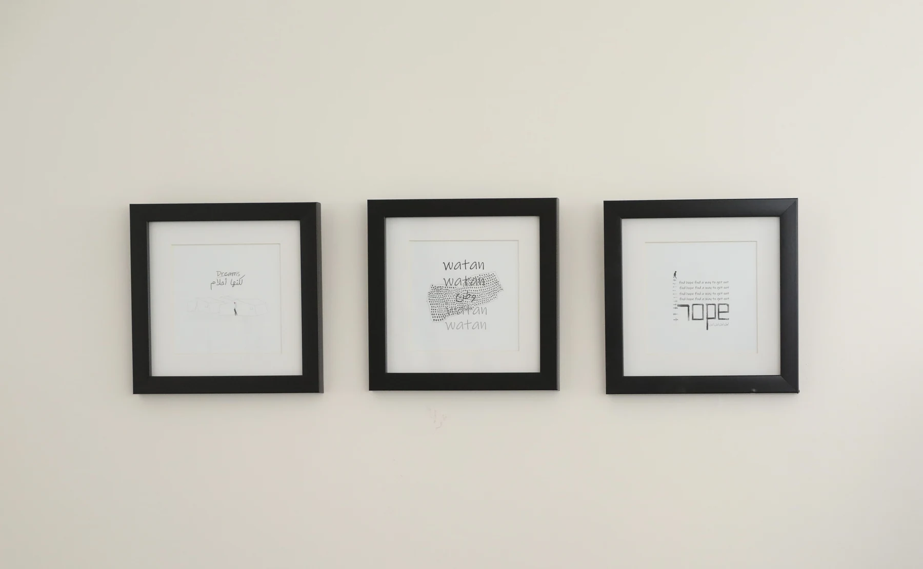 Three small framed works from S A B installed on a white gallery wall.